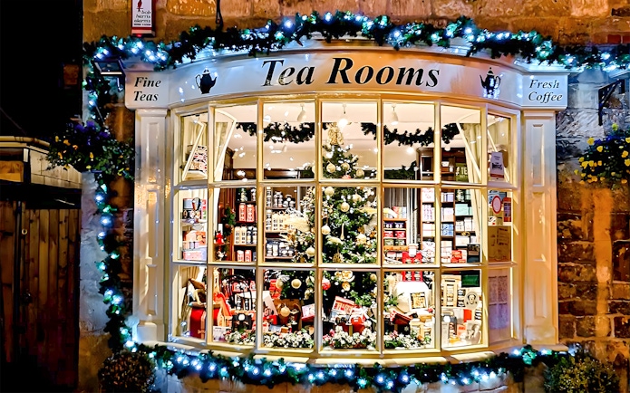 Cotswolds tea room window with festive decorations and tea products on display.