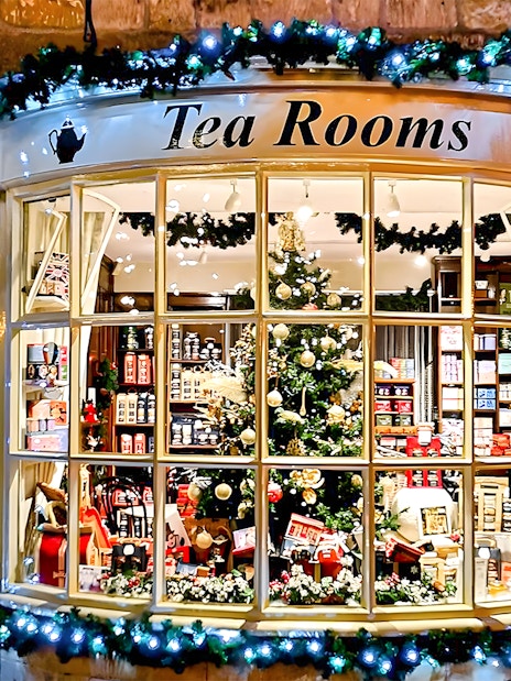 Cotswolds tea room window with festive decorations and tea products on display.