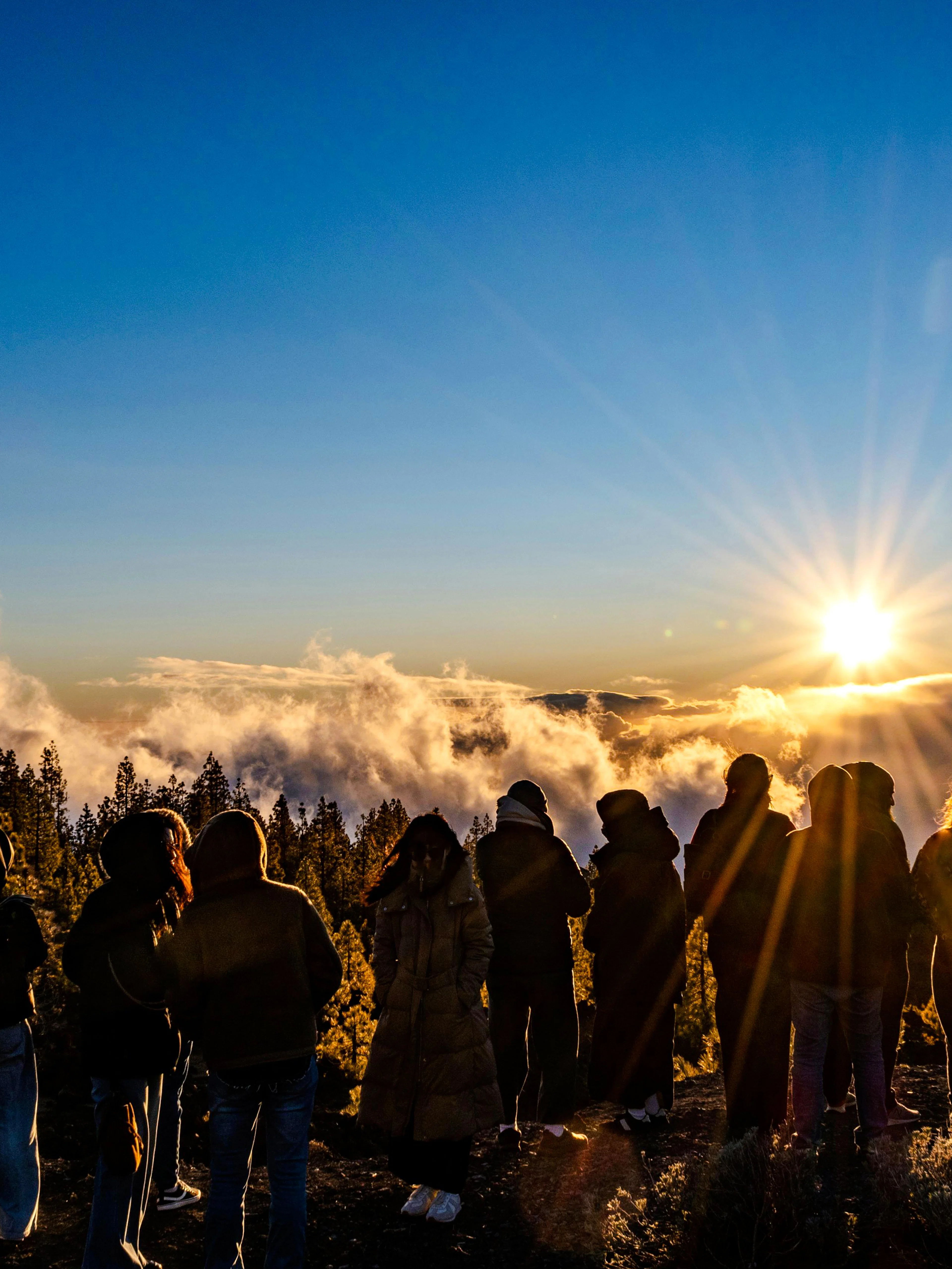 Tour group watching sunset above clouds in Mount Teide National Park, Tenerife.