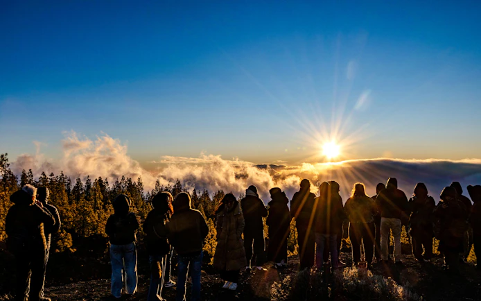 Tour group watching sunset above clouds in Mount Teide National Park, Tenerife.