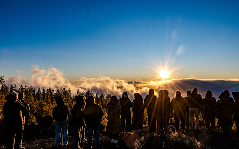 Tour group watching sunset above clouds in Mount Teide National Park, Tenerife.