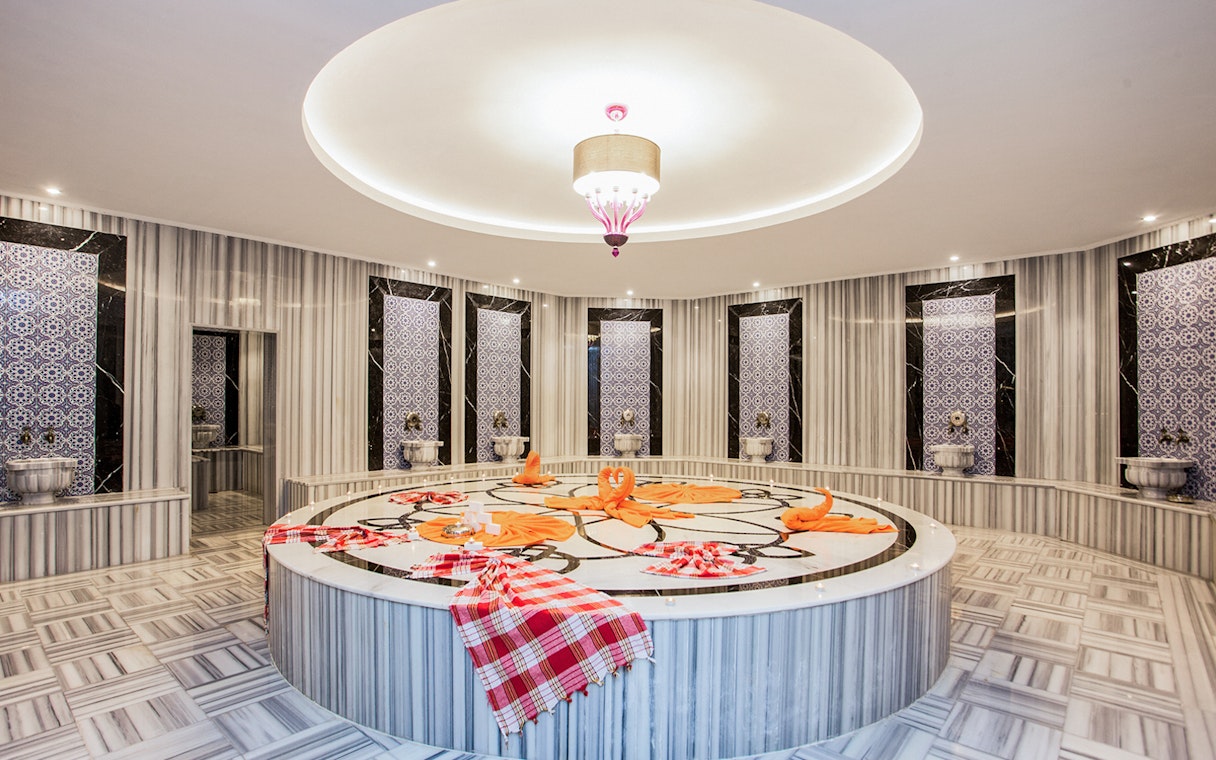 Marble interior of Hammam Bath and Spa in Cappadocia with ornate tiles and central platform.