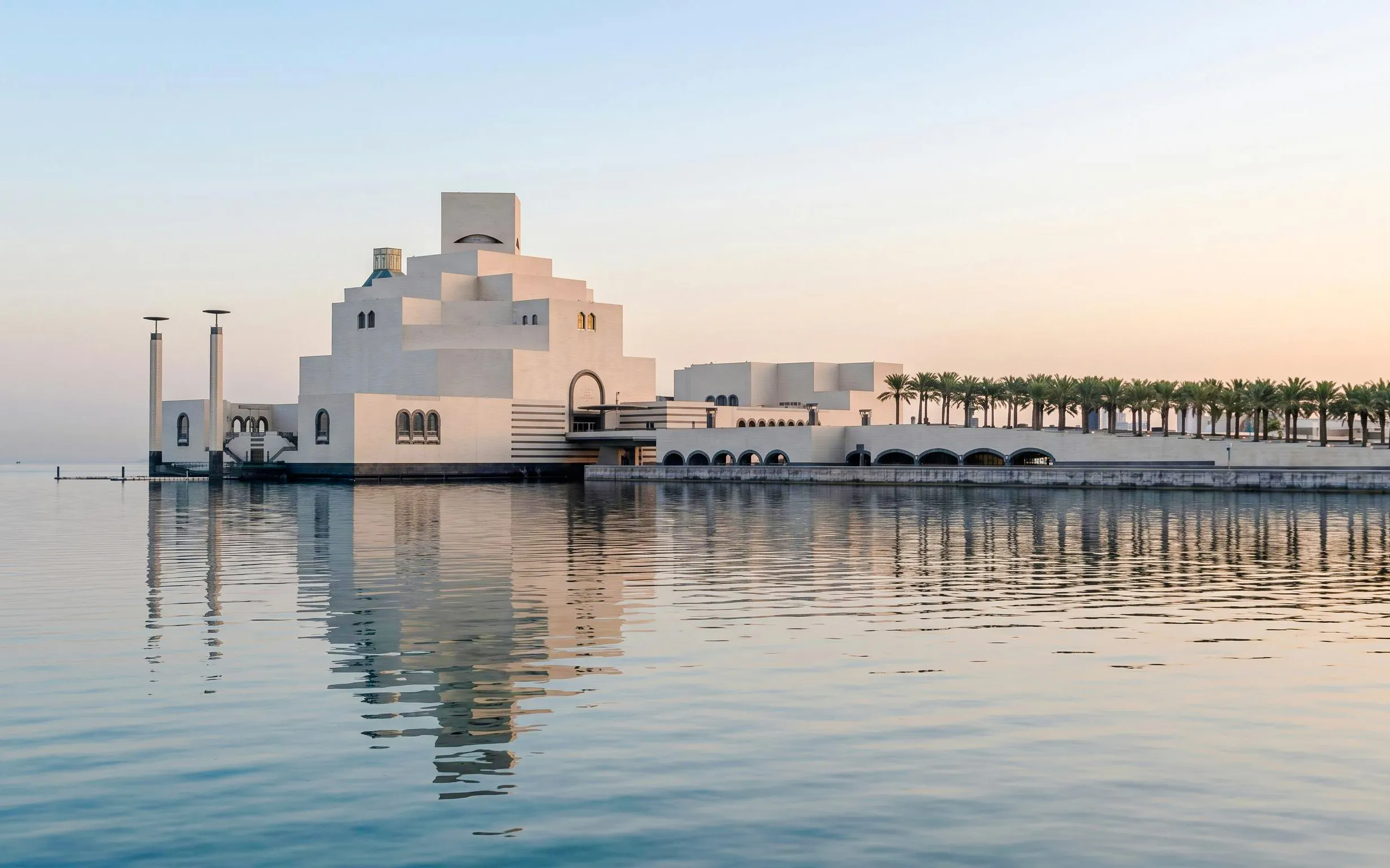 Museum of Islamic Art in Doha with modern architecture reflected in the water.