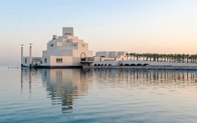 Museum of Islamic Art in Doha with modern architecture reflected in the water.