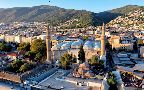 Bursa Grand Mosque with surrounding cityscape and mountains in Istanbul.