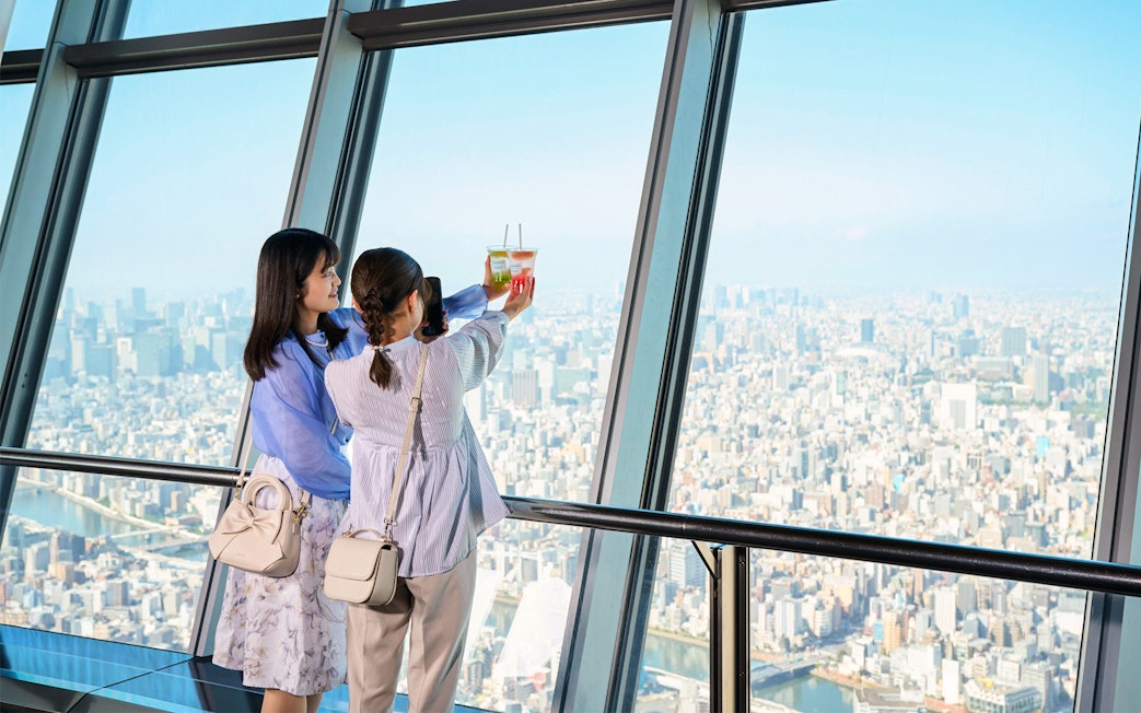 Tourists on Tembo Deck enjoying city view with soft drinks.