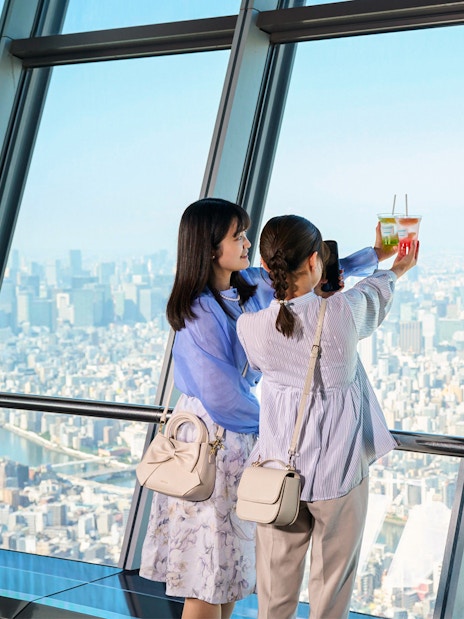 Tourists on Tembo Deck enjoying city view with soft drinks.