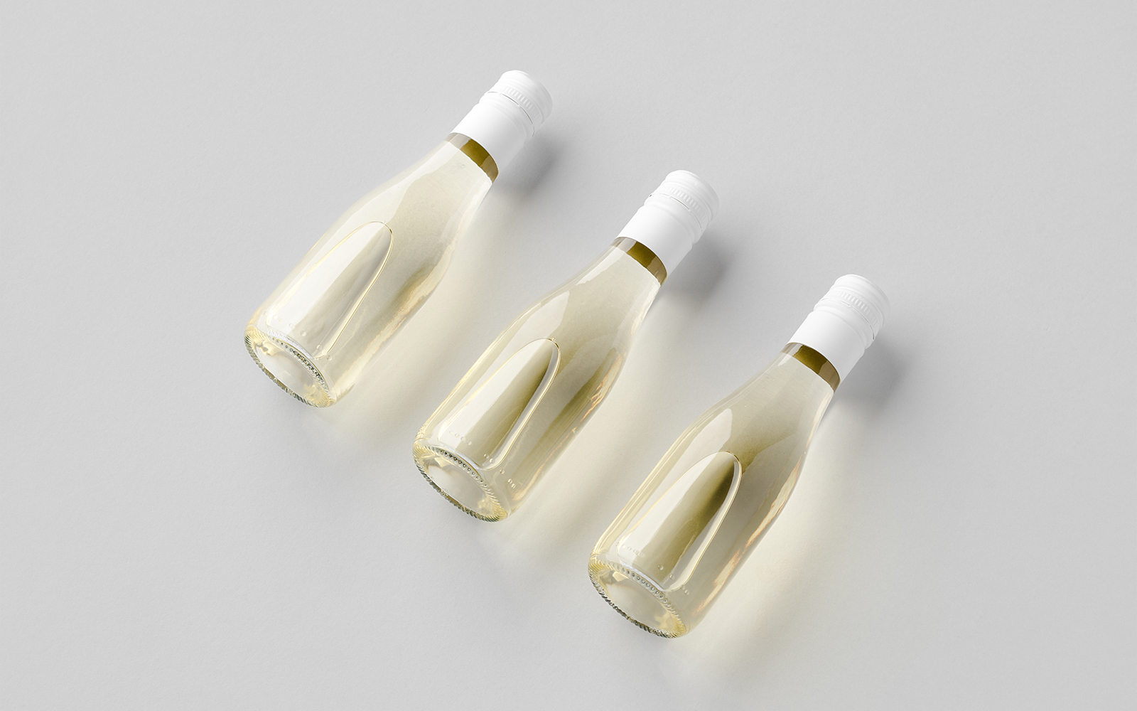 Three miniature wine bottles from Queen Mary's Doll House cellar.