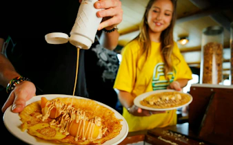 Dutch pancakes being topped with syrup on a cruise in Amsterdam.