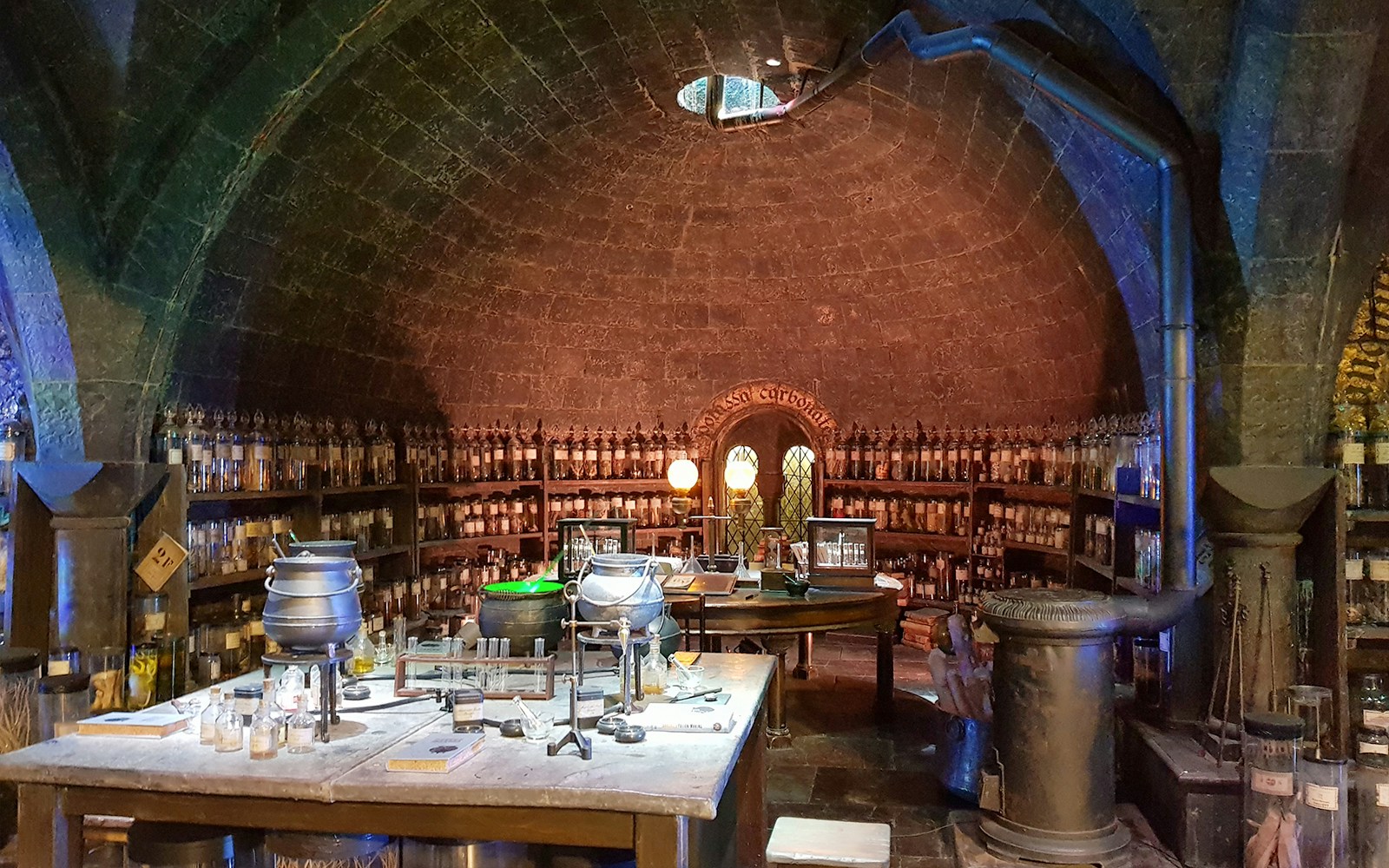 Potion's classroom with cauldrons and shelves of ingredients at Harry Potter Studio Tour.