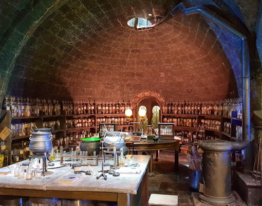 Potion's classroom set at Harry Potter Studio Tour, featuring cauldrons and potion bottles.