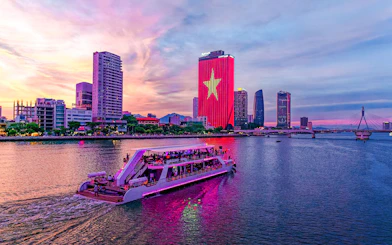 Poseidon cruise on Han River with Da Nang skyline at sunset.