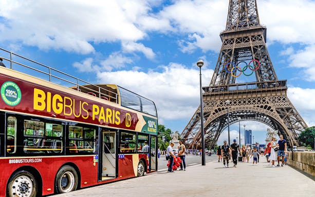 Big Bus Paris tour near Eiffel Tower with Olympic rings, Paris, France.