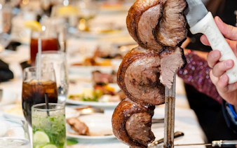 Skewered meat being served at a Brazilian steakhouse in Rio de Janeiro.