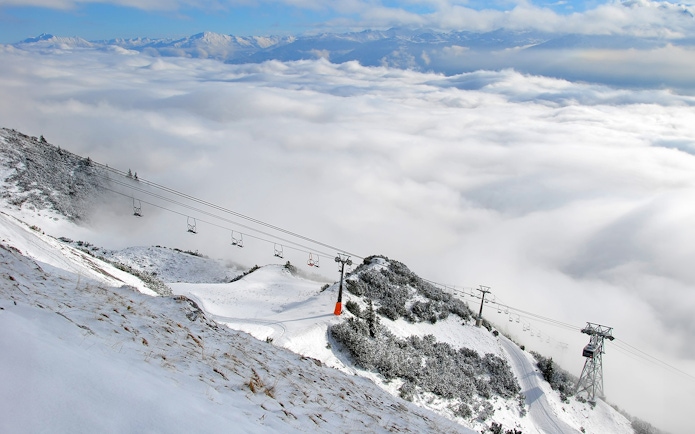 Nordkettenbahn cable car ascending snowy mountain in Innsbruck, Austria.