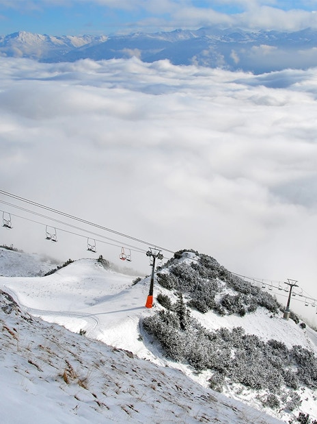Nordkettenbahn cable car ascending snowy mountain in Innsbruck, Austria.