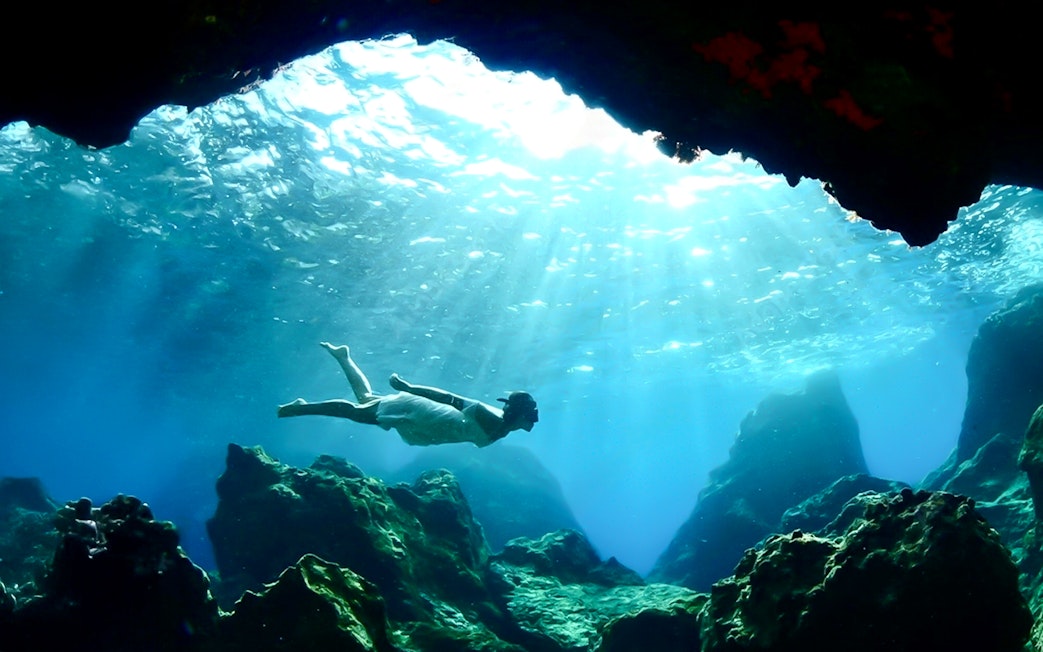 Swimming in the blue caves with sunlight filtering through water.