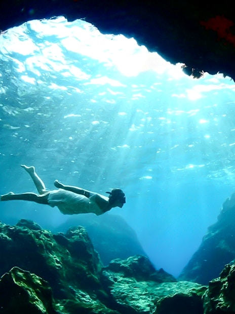 Swimming in the blue caves with sunlight filtering through water.