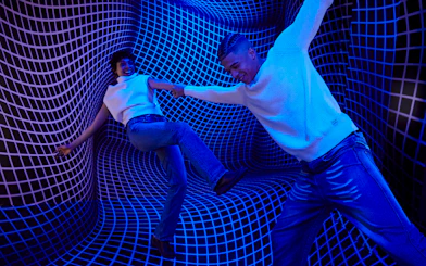 Guests interacting in a blue optical illusion room at the Twist Museum, London.