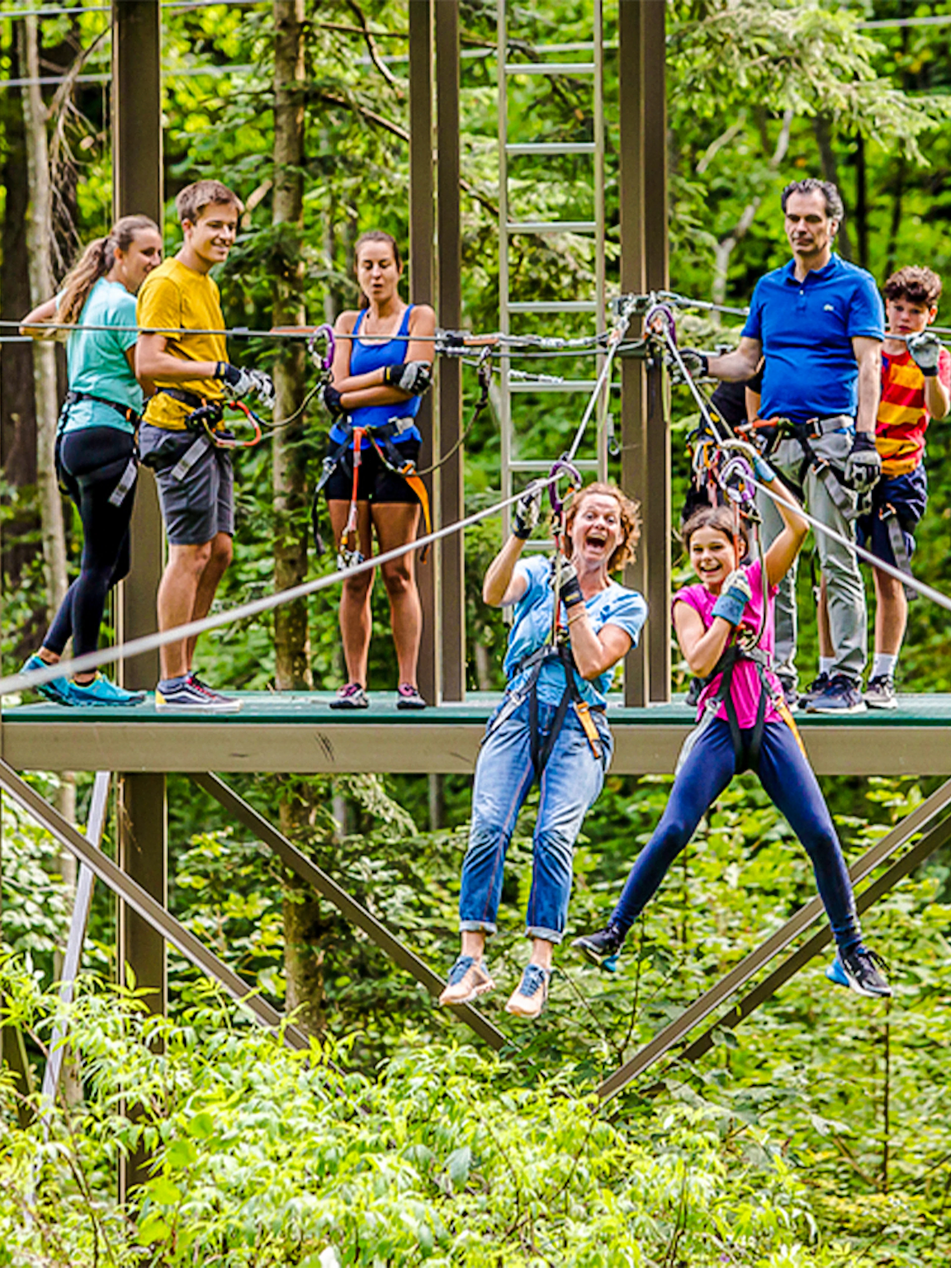Participants enjoying a zipline at Ropes Park Interlaken amidst lush greenery.