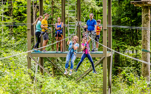 Participants enjoying a zipline at Ropes Park Interlaken amidst lush greenery.