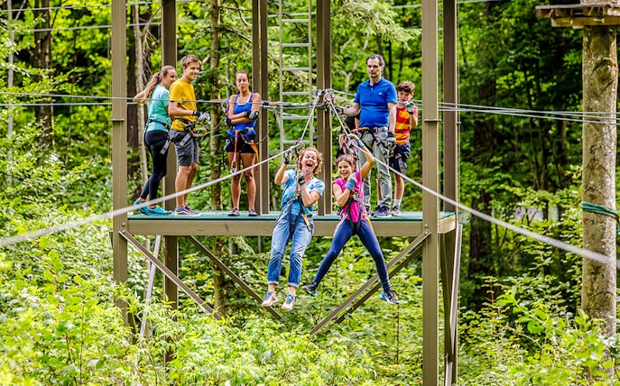Participants enjoying a zipline at Ropes Park Interlaken amidst lush greenery.