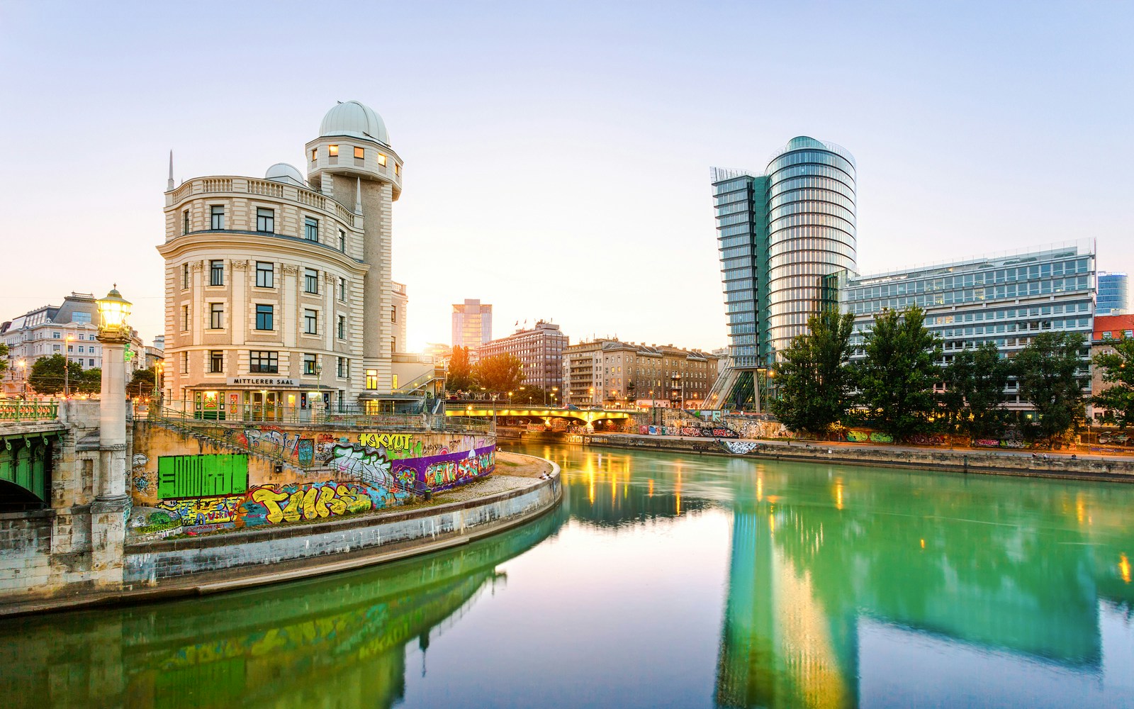 Urania building in Vienna reflected in the Donaukanal Danube Canal at sunset.