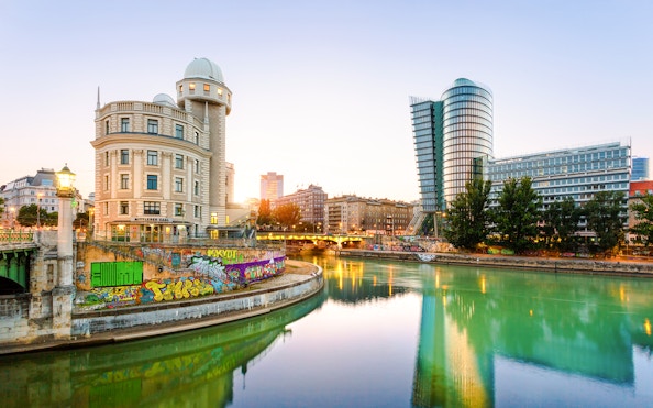 Urania building in Vienna reflected in the Donaukanal Danube Canal at sunset.