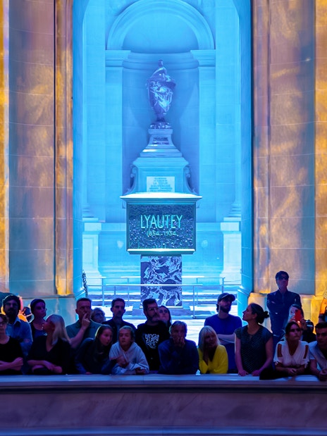 Audience at Aura Immersive show, Invalides stage with colorful light projections.