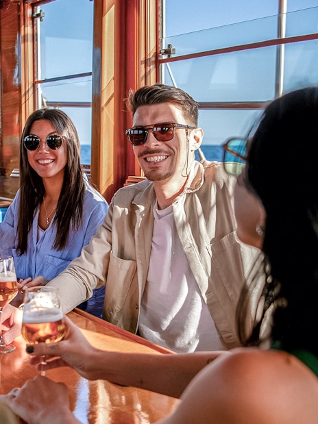 Group enjoying drinks on a catamaran in Barcelona.