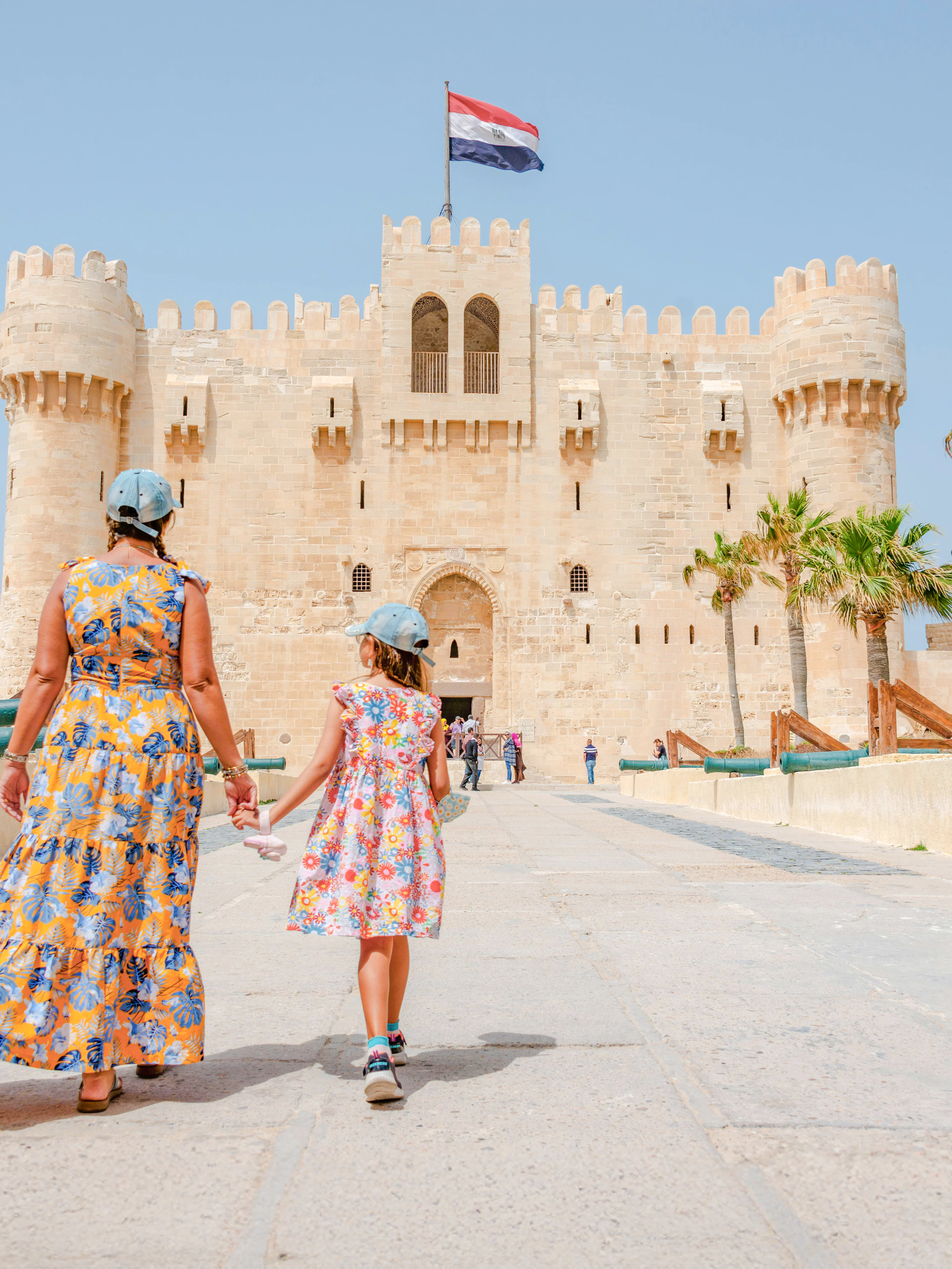 Woman and daughter entering Qaitbay Citadel, Alexandria, exploring historic fortress.