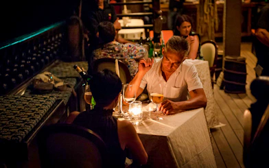 Couple dining by candlelight on a Galleon Dinner Cruise in Venice.