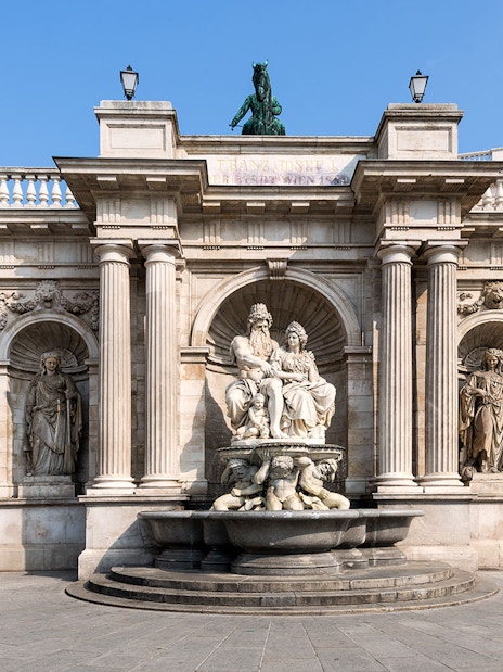 Albertina Museum entrance with ornate statues and fountain in Vienna.