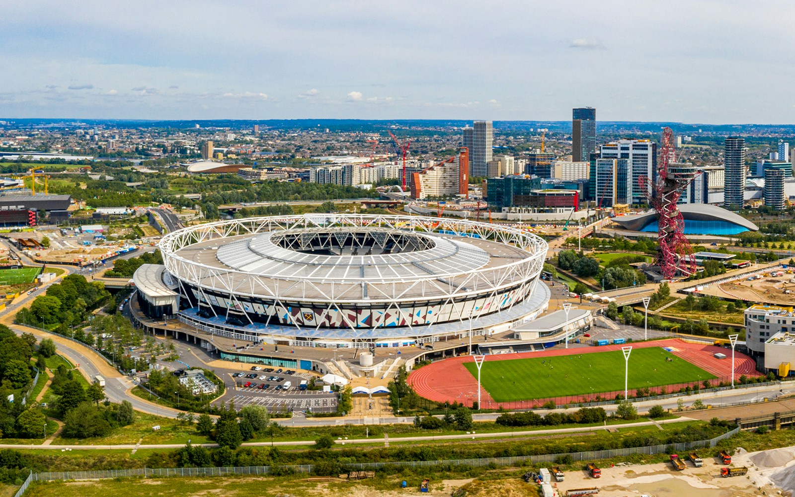 Aerial view of Olympic Stadium in London with cityscape in the background.