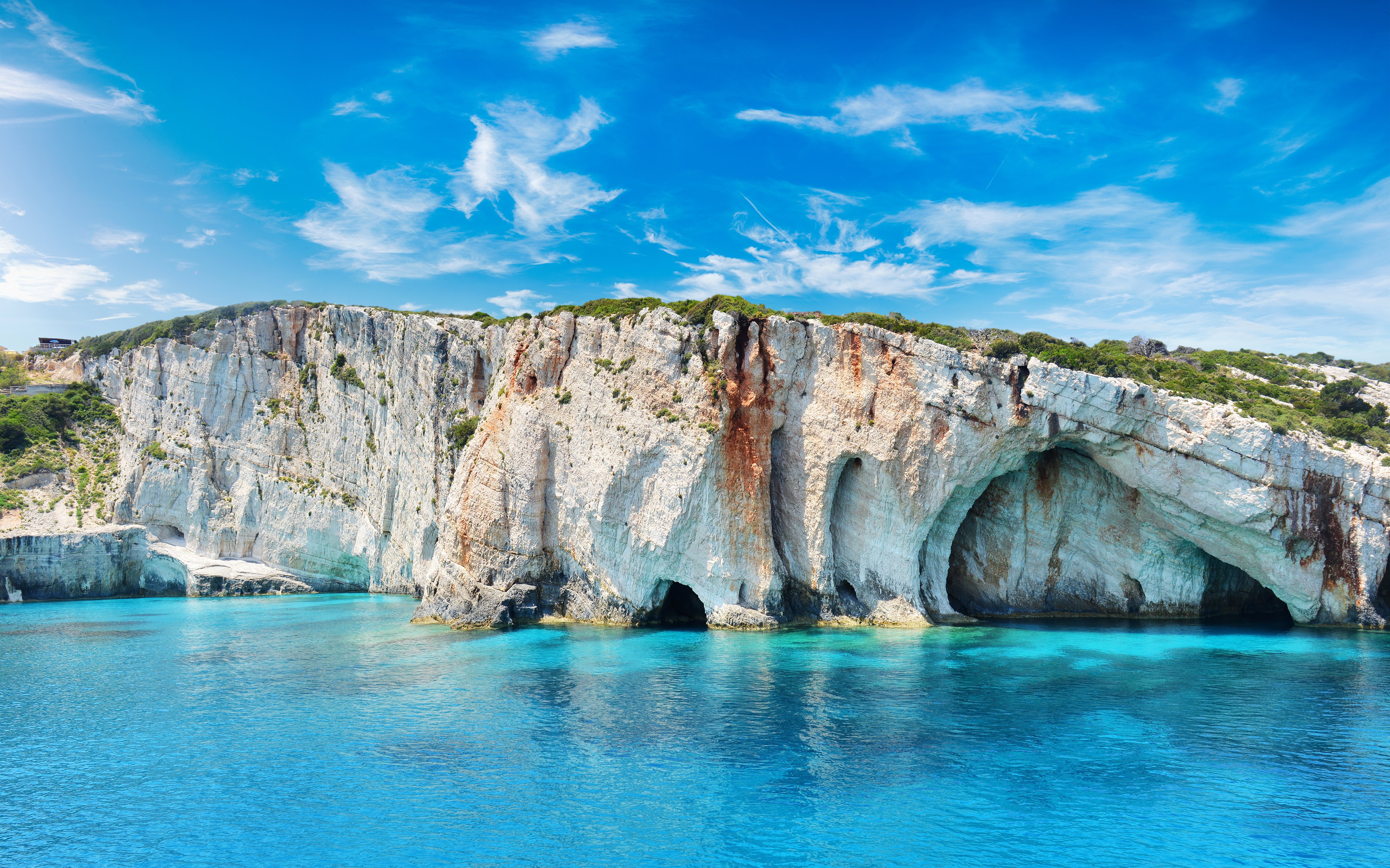 Blue Caves on Zakynthos Island, Greece with clear turquoise water and rocky cliffs.