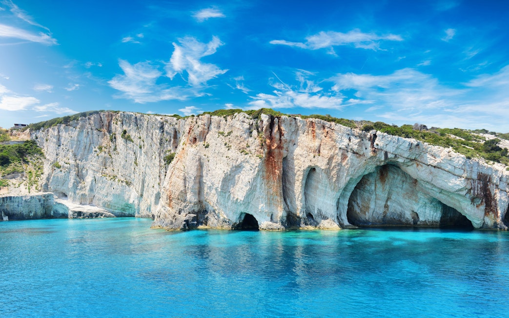 Blue Caves on Zakynthos Island, Greece with clear turquoise water and rocky cliffs.