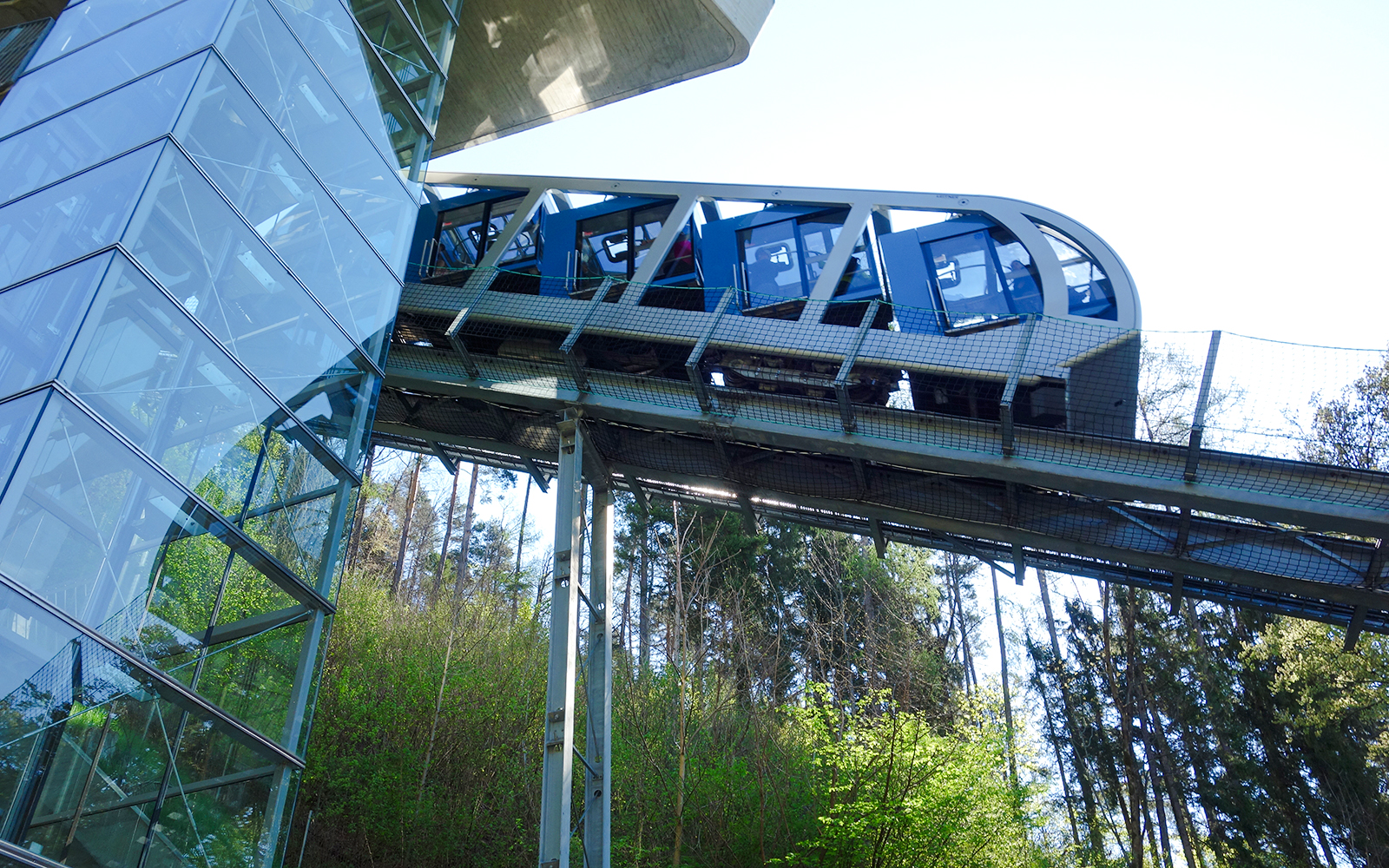 Hungerburg Funicular ascending through forested area near station.