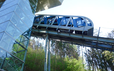 Hungerburg Funicular ascending through forested area near station.