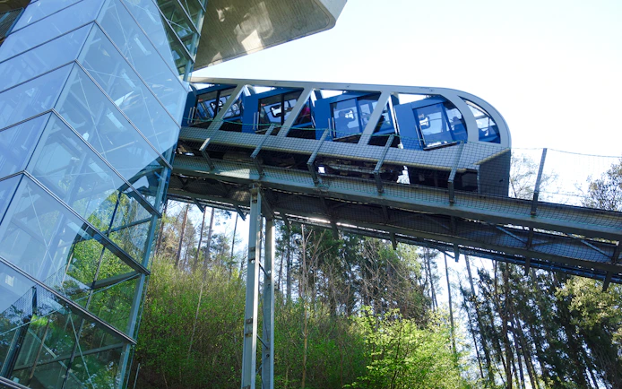 Hungerburg Funicular ascending through forested area near station.