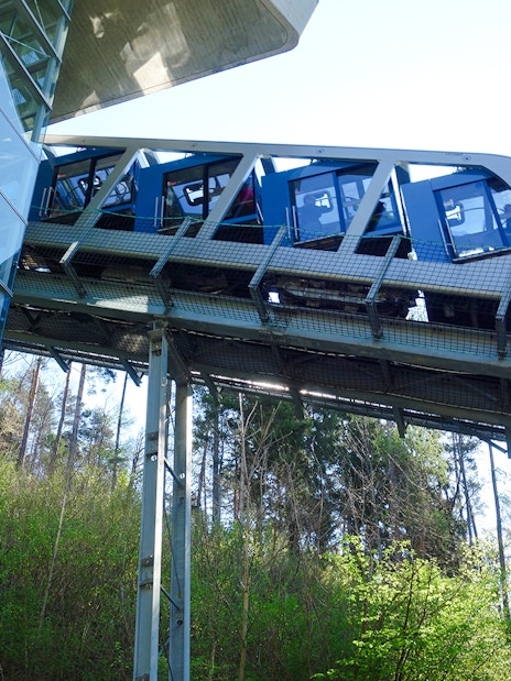 Hungerburg Funicular ascending through forested area near station.