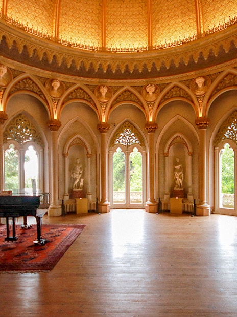 Monserrate Palace interior with grand piano and ornate arches in Sintra, Portugal.