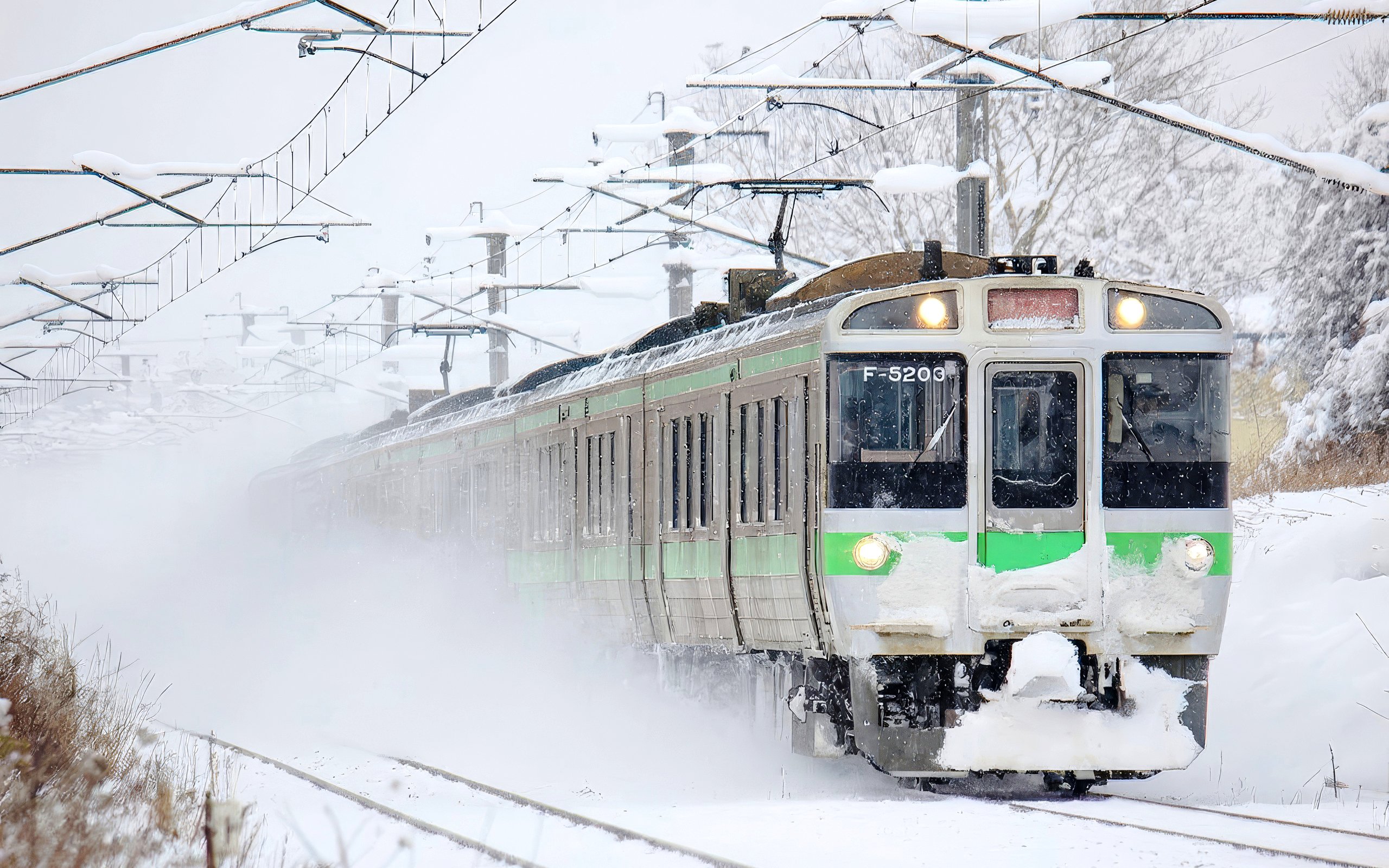 Train traveling through snowy landscape in Hokkaido, Japan, using JR Hokkaido Rail Pass.