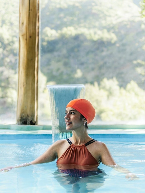 Tourist relaxing in indoor pool at Santuario del Río Spa, Cajón del Maipo, Chile.