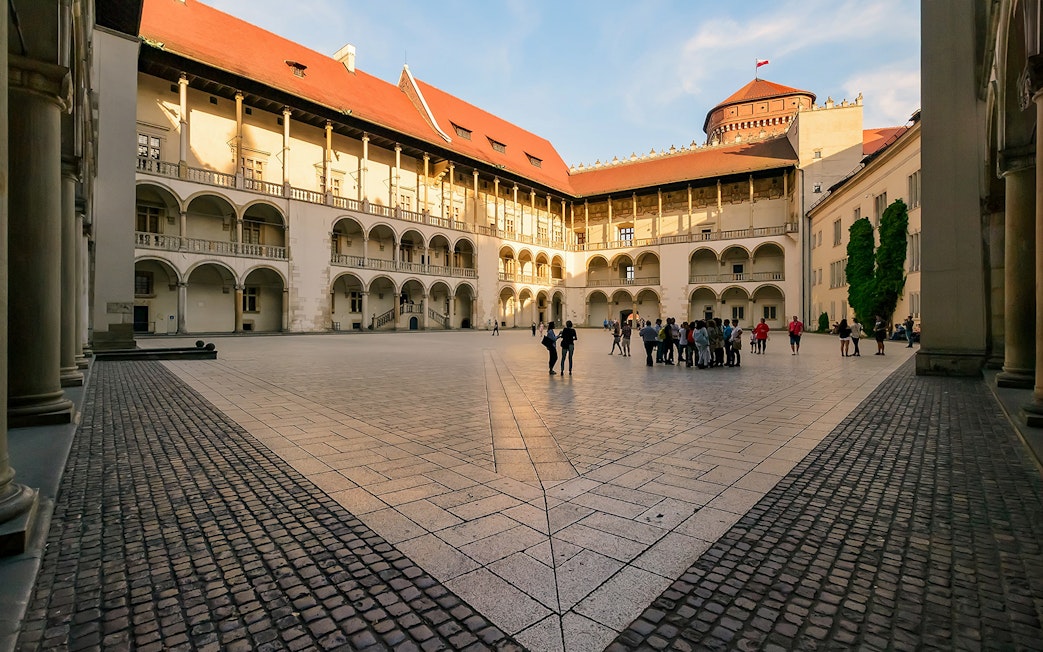 Wawel Castle courtyard with tourists in Krakow, Poland.