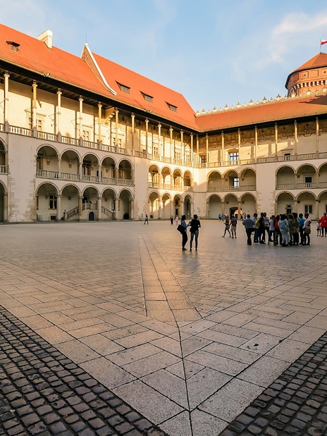 Wawel Castle courtyard with tourists in Krakow, Poland.