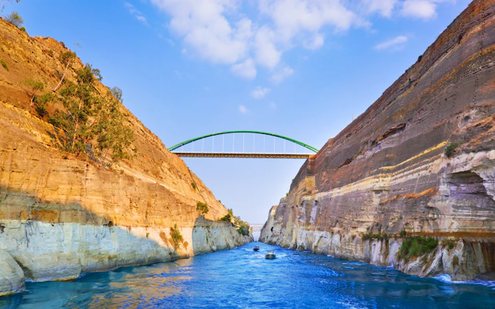 Corinth Canal in Greece with boats passing under a bridge.