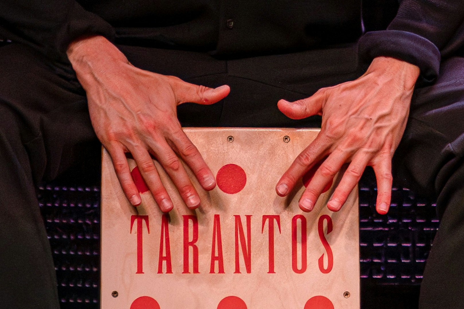 Hands playing a cajón at Los Tarantos Flamenco Show.
