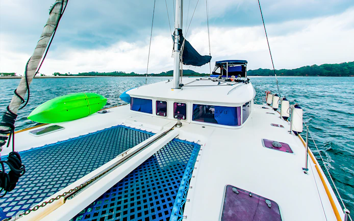 Private yacht charter deck with kayak on open sea.