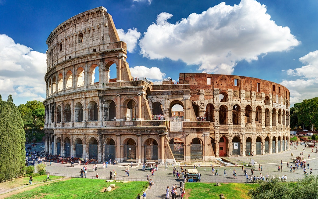 Colosseum in Rome with tourists exploring the ancient amphitheater.