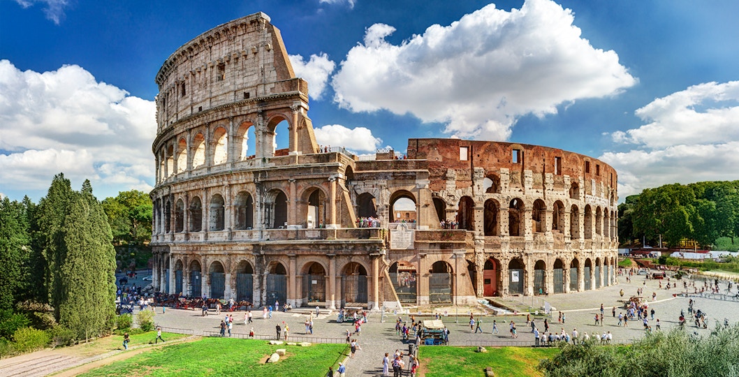 Colosseum in Rome with tourists exploring the ancient amphitheater.